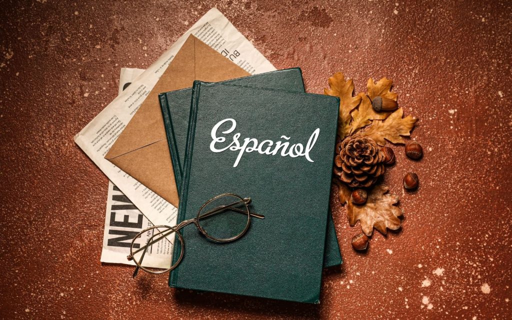 Üzerinde 'Español' yazılı yeşil ciltli kitaplar ve doğal öğeler