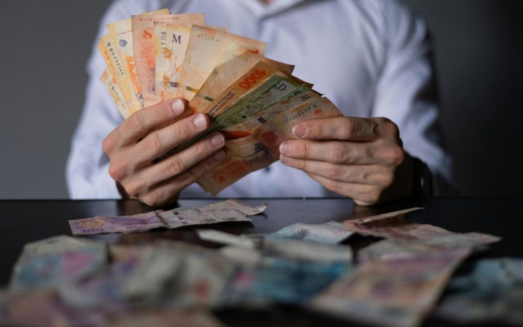 Bir kişinin elinde Arjantin parasını saydığı bir an